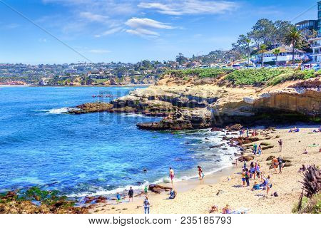 Popular Seaside Town Of La Jolla Cove In San Diego With A Crowd On The Beach, Canoers On The Waters,