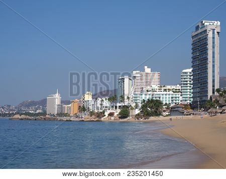 Scenic Sandy Beach Panorama At Bay Of Acapulco City In Mexico With White Hotels Buildings And Skyscr