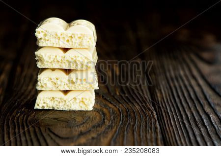 Pyramid Of White Porous Chocolate On A Wooden Vintage Old Background In The Style Of Moodle