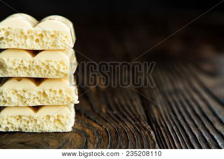 Pyramid Of White Porous Chocolate On A Wooden Vintage Old Background In The Style Of Moodle