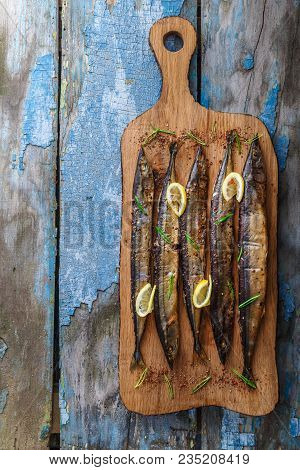 Smoked Oceanic Saury On Wooden Cutting Board, Top View, Copy Space.