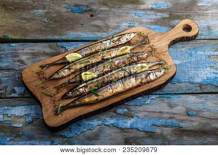 Smoked Oceanic Saury On Wooden Cutting Board, Top View, Copy Space.