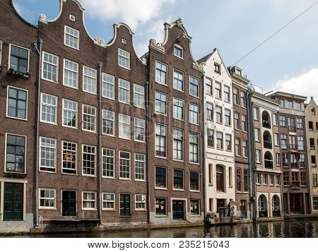 Amsterdam, Netherlands - April 20, 2017: Typical Gabled Houses On Damrak Street In Amsterdam, Hollan