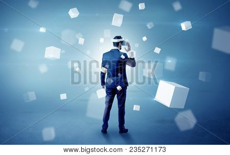 Handsome businessman with vr goggle and falling white cubes around