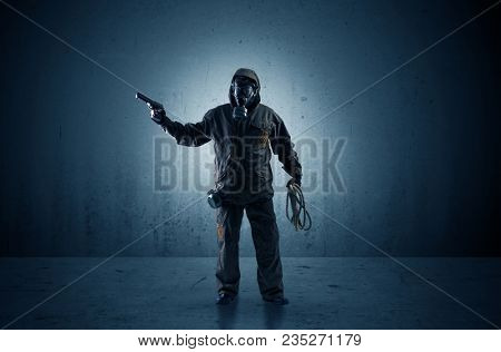 Bad agent in a dark room with arms on his hand and gas mask