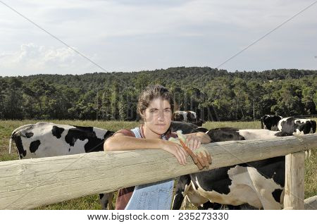 Portrait Of A Farmer With Her Cows In The Field