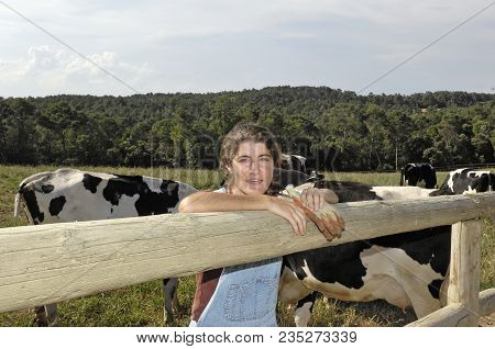 Portrait Of A Farmer With Her Cows In The Field