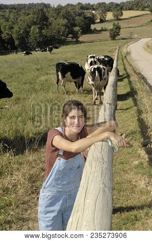 Portrait Of A Farmer With Her Cows In The Field