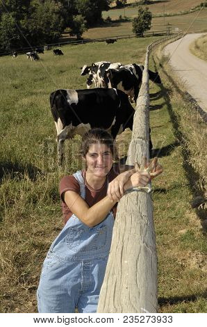 Portrait Of A Farmer With Her Cows In The Field