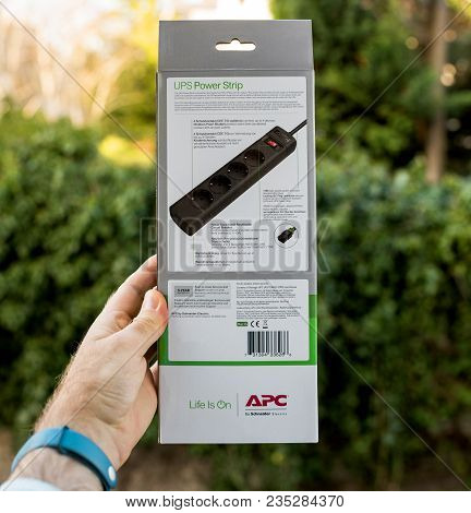 Paris, France - Mar 31, 2018: Man Holding Against Green Background The Instruction Of An Apc Ups Pow
