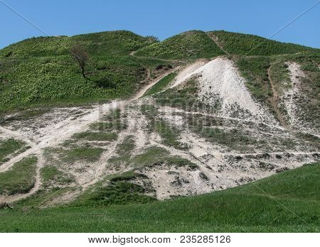 Cretaceous Hill In Spring, Covered With Green Grass, With Paths, Against A Clear Blue Sky