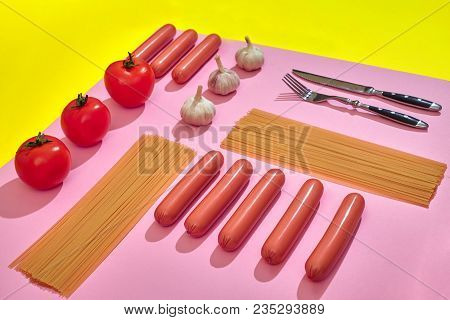 A Lot Of Raw Sausages With Pasta And Vegetables On Pink And Yellow Background, Top View. Still Life.