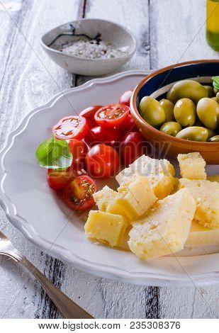 Antipasti Plate Of Parmesan, Cherry Tomatoes, Olives And Almonds
