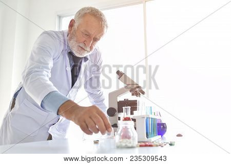 Senior Male Research Scientist Is Using Micropipette Filling Test Tubes In The Laboratory.