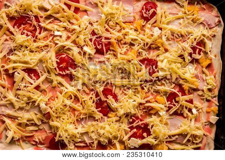 Top Viwev Of Raw Pizza With Cheese, Tomato And Sausages Ready To Cook