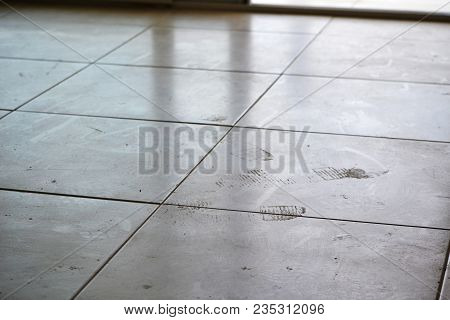 Dirty Footprints On White Tile On The Floor. Dirty Dusty Floor