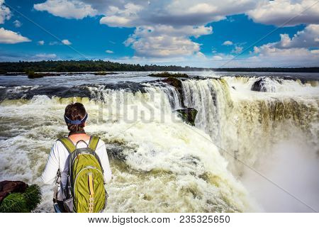 Energetic woman with a tourist backpack watching waterfalls the Garganta del Diablo/ Devil's Throat. Concept of active and extreme tourism