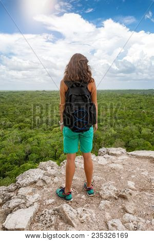 Traveler Woman Enjoys The View From The Top Of The Nohoch Mul Pyramid In Coba, Yucatan, Mexico