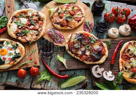 Top View Of Freshly Prerared Delicious Pizzas. Italian Style Rustic Pizzas With Eggs, Salami, Mushro