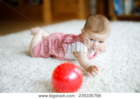 Cute Baby Playing With Red Gum Ball. Lttle Girl Looking At The Camera And Crawling. Family, New Life