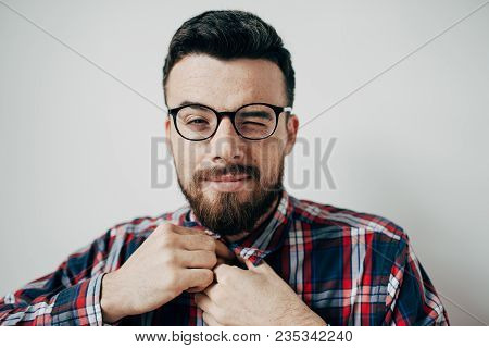 Attrsctive And Handsome Guy Si Looking To The Camera Nad Blinking. He Wears Good Shirt And Nice Neck