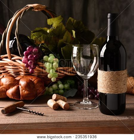 Wine Still Life: An old fashioned cork screw, a basket of grapes and leaves, a loaf of bread and some corks and an empty wineglass round out the scene. 