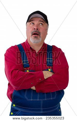 Bored Farmer Or Worker In Dungarees Rolling His Eyes With His Mouth Open As Though Talking As He Sta