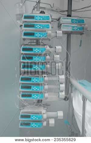Automatic Drug Perfusion Devices In Stack At The Hospital Room's Bed