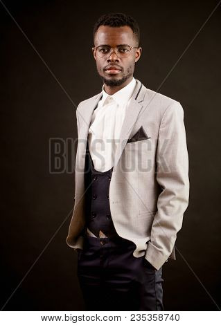 Leader In Glasses And In Fasionable Clothes Is Standing With Sticking Hands In Pockets. Africam Mach