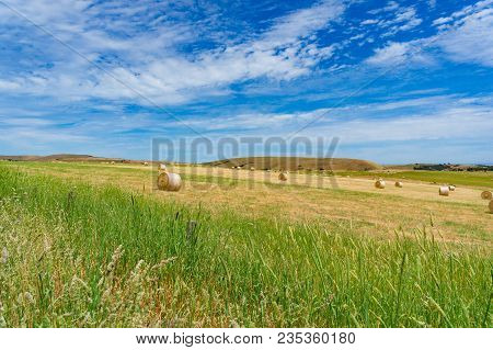 Spectacular Landscape Of Countrryside Field With Strawbales On Sunny Day