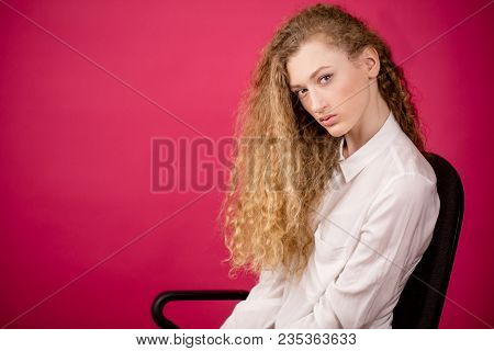 Close Up Photo Of Attractive Woman With Perfect Hair Curls Sitting On The Chair. Beautiful Golden Tr