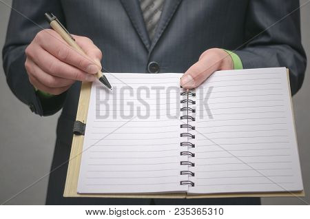 Businessman Holds In Hand A Note Pad With Pen. To Do List Template. Goals Or Business Tricks. Busine