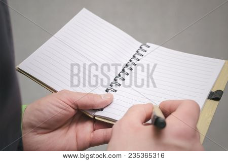 Businessman Holds In Hand A Note Pad With Pen. To Do List Template. Goals Or Business Tricks. Busine