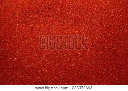 Texture Of A Colored Granular Sand Close Up. Red Grains