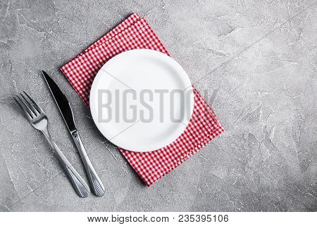 Empty White Plate With Nupkin On A Gray Stone Background