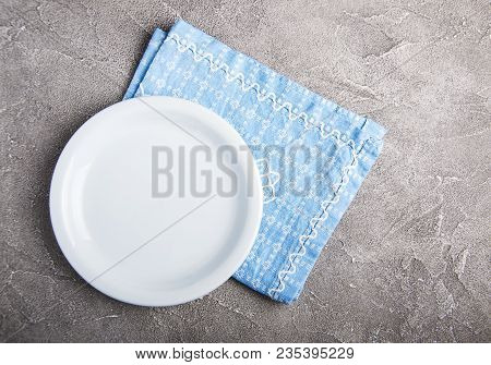 Empty White Plate With Nupkin On A Gray Stone Background