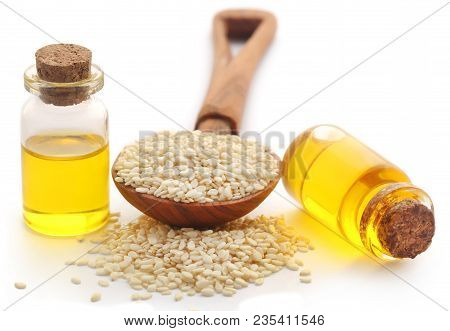 Peeled Sesame Seeds With Oil In Bottle Over White Background