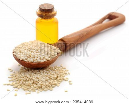 Peeled Sesame Seeds With Oil In Bottle Over White Background