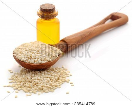 Peeled Sesame Seeds With Oil In Bottle Over White Background