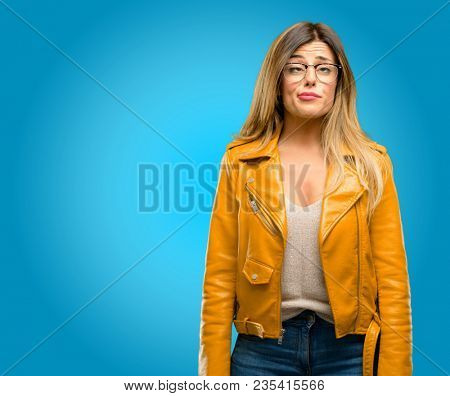 Beautiful young woman making funny face fooling, blue background