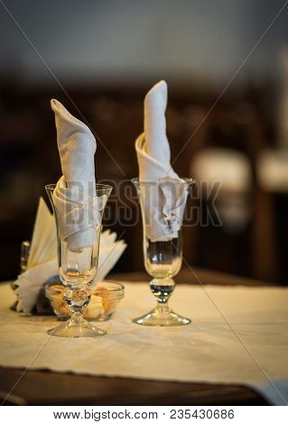 Wine Glasses On A Wooden Table With White Napkings