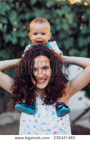 Beautiful Brunette Mother With Baby Boy 
In The Garden