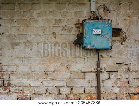 Old And Dangerous Rusty Blue Electric Fuse Box On Grunge Brick Wall.