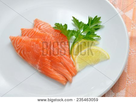 Salmon On White Plate Vith Lemon And Greens