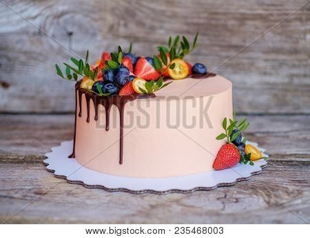 Beautiful Homemade Cake With Cream Cheese Frosting , Strawberries And Blueberries On A Wooden Table