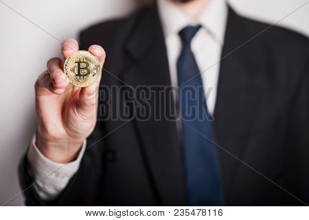 Golden Bitcoin In A Man Hand, Digitall Symbol Of A New Virtual Currency. Man Recived Money From Bitc