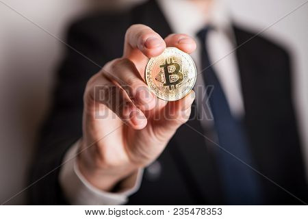 Golden Bitcoin In A Man Hand, Digitall Symbol Of A New Virtual Currency. Man Recived Money From Bitc