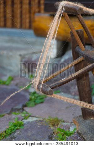 Old Woolen Spinner Tool At Work Outdoors.