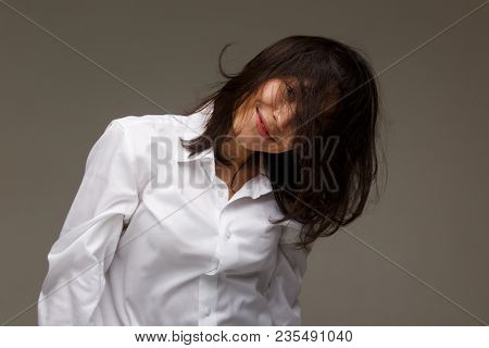 Beautiful Girl In A White Shirt Shows Emotions - Smile, Fun. On A Light Background.