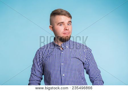 Portrait Of A Handsome Young Man Smiling Against Blue Background